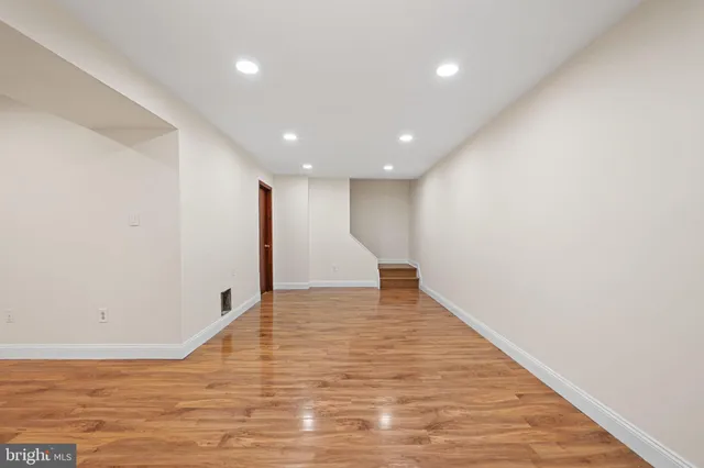 a view of an empty room with wooden floor