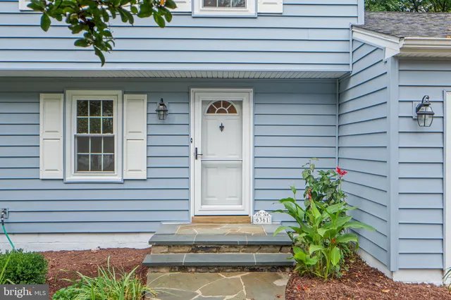 a front view of a house with plants