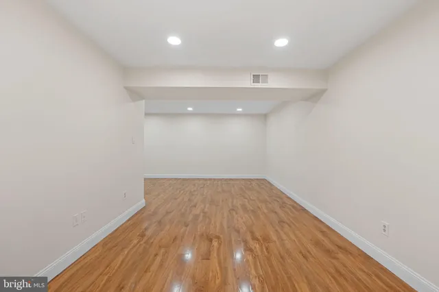 a view of a room with wooden floor and white walls