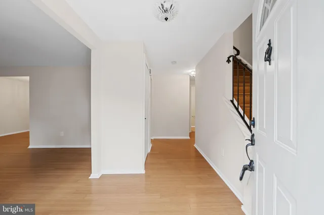 a view of a hallway with wooden floor and staircase
