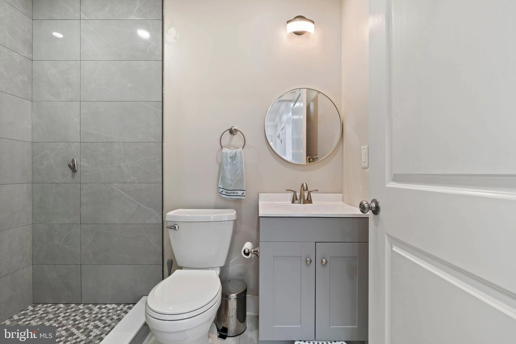 1901 Jackson Street Cinnaminson, NJ 08077 - Photo 19 of 40 a bathroom with a toilet a sink a mirror and vanity