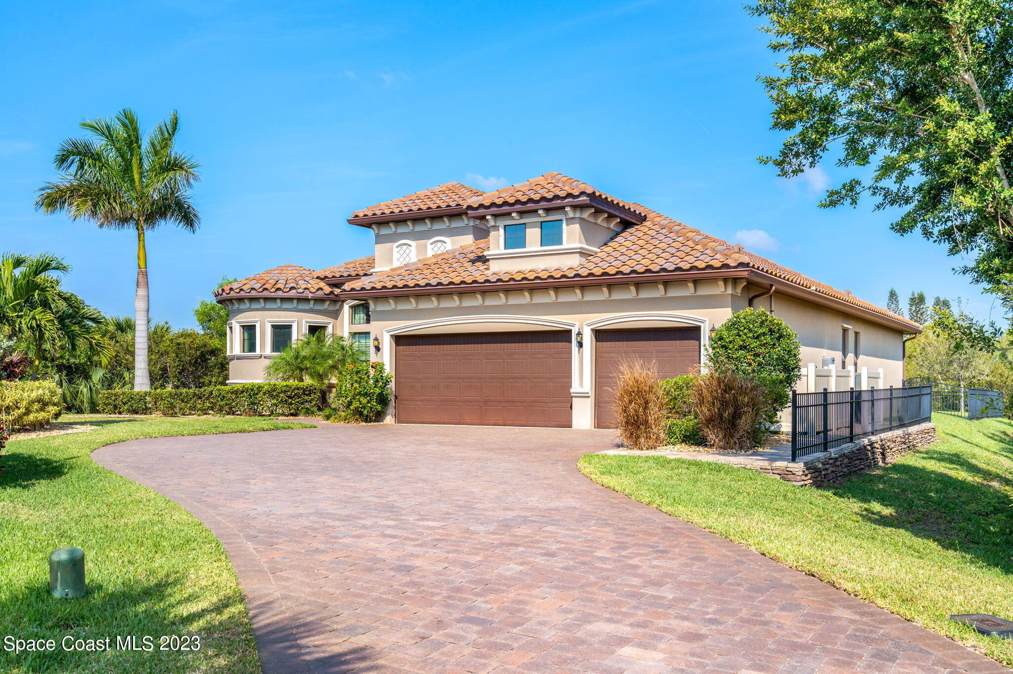 a front view of a house with a yard and potted plants