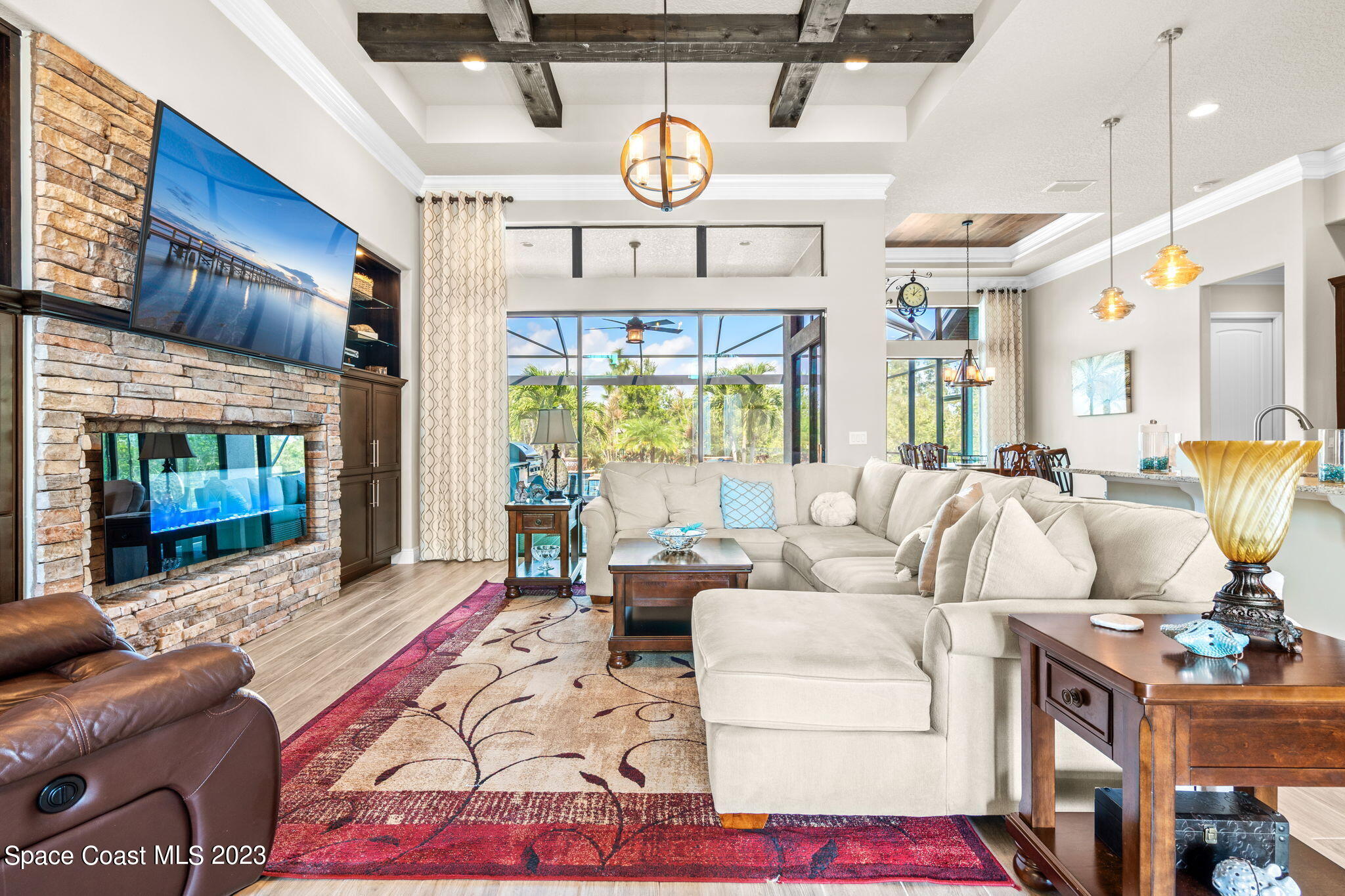 5530 Calder Drive Melbourne, FL 32940 - Photo 12 of 63 a living room with furniture a fireplace and a chandelier