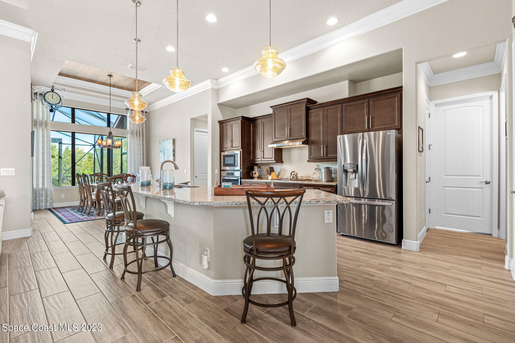 5530 Calder Drive Melbourne, FL 32940 - Photo 14 of 63 a kitchen with stainless steel appliances a dining table chairs stove refrigerator and cabinets