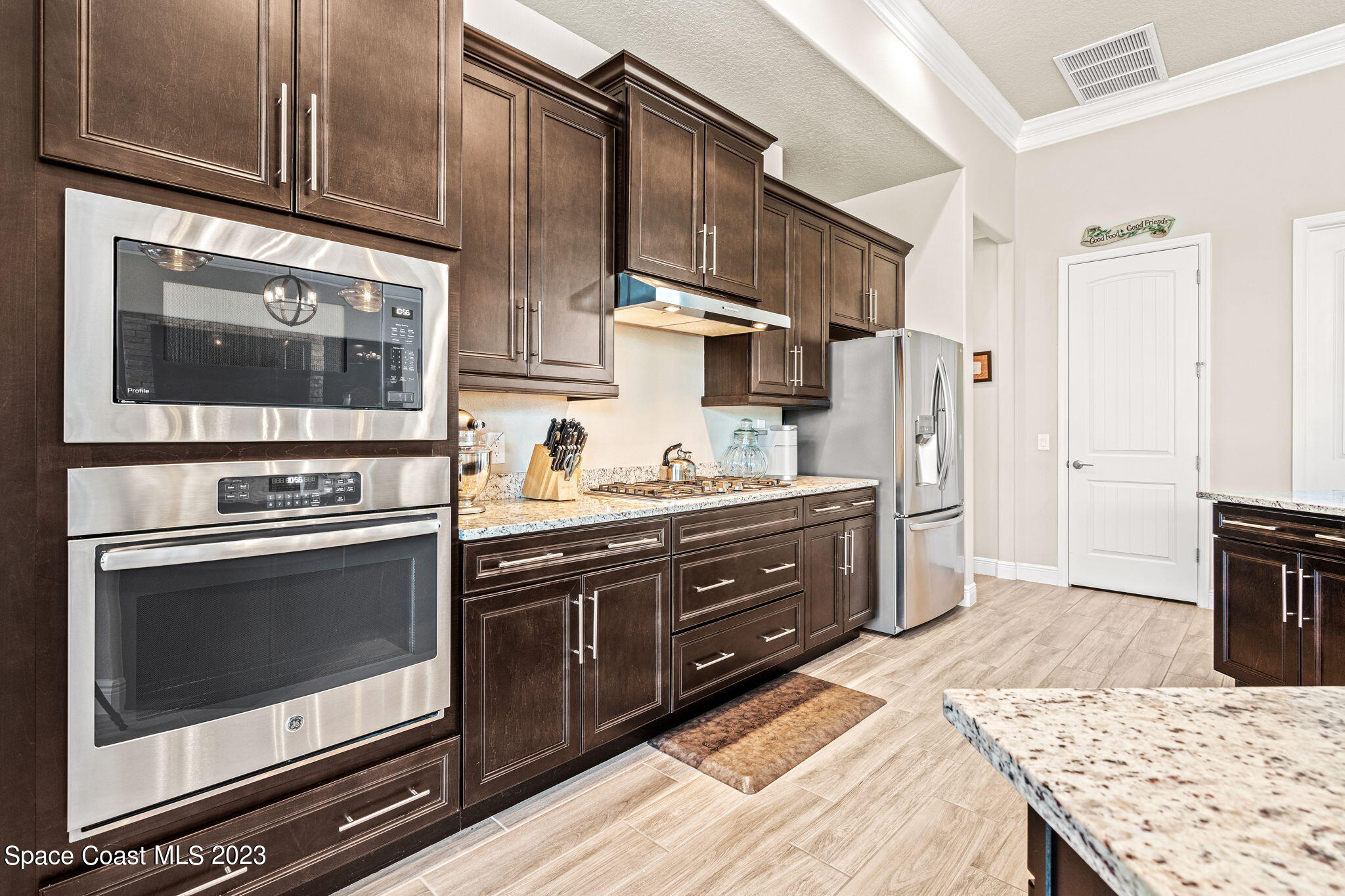 5530 Calder Drive Melbourne, FL 32940 - Photo 15 of 63 a kitchen with stainless steel appliances kitchen island granite countertop a stove refrigerator and cabinets