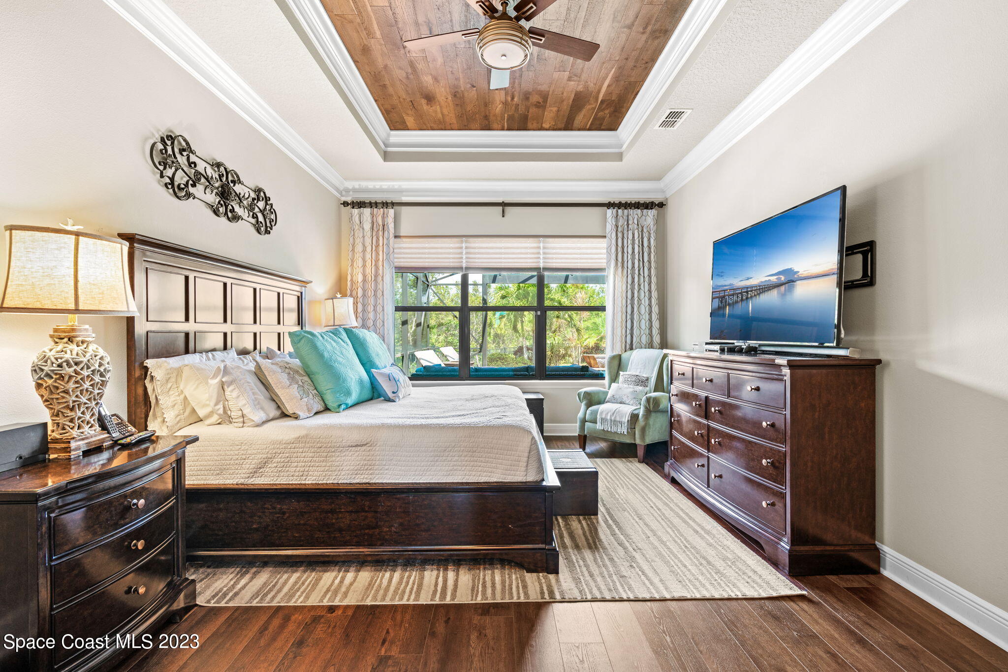 5530 Calder Drive Melbourne, FL 32940 - Photo 26 of 63 a spacious bedroom with a bed and a chandelier