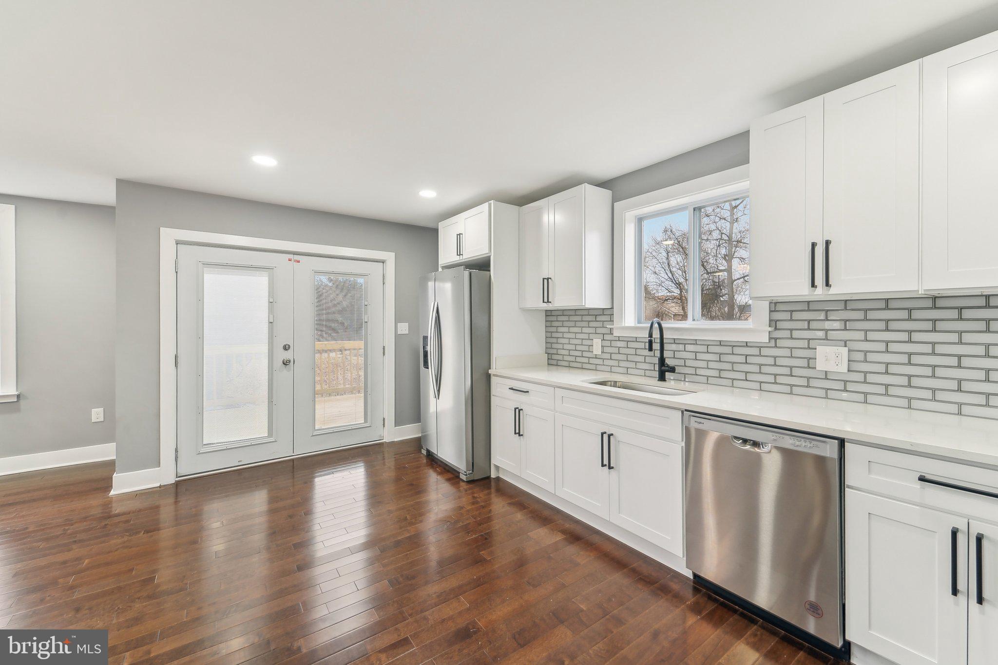 7008 Windsor Mill Road Baltimore, MD 21207 - Photo 14 of 34 a large hall with stainless steel appliances granite countertop a sink and dishwasher with wooden floor