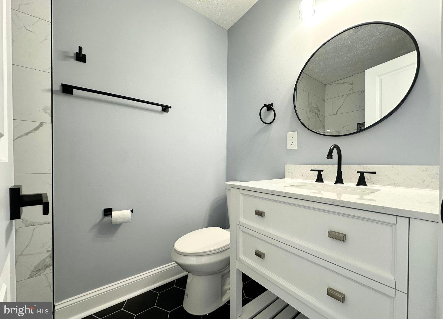 1855 Montreal Road Severn, MD 21144 - Photo 19 of 30 a bathroom with a toilet a sink and mirror