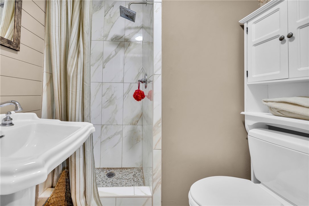 3030 Smith McGee Road Iva, SC 29655 - Photo 36 of 46 A compact and well-appointed bathroom featuring a pedestal sink and a tiled shower with a rainfall showerhead.