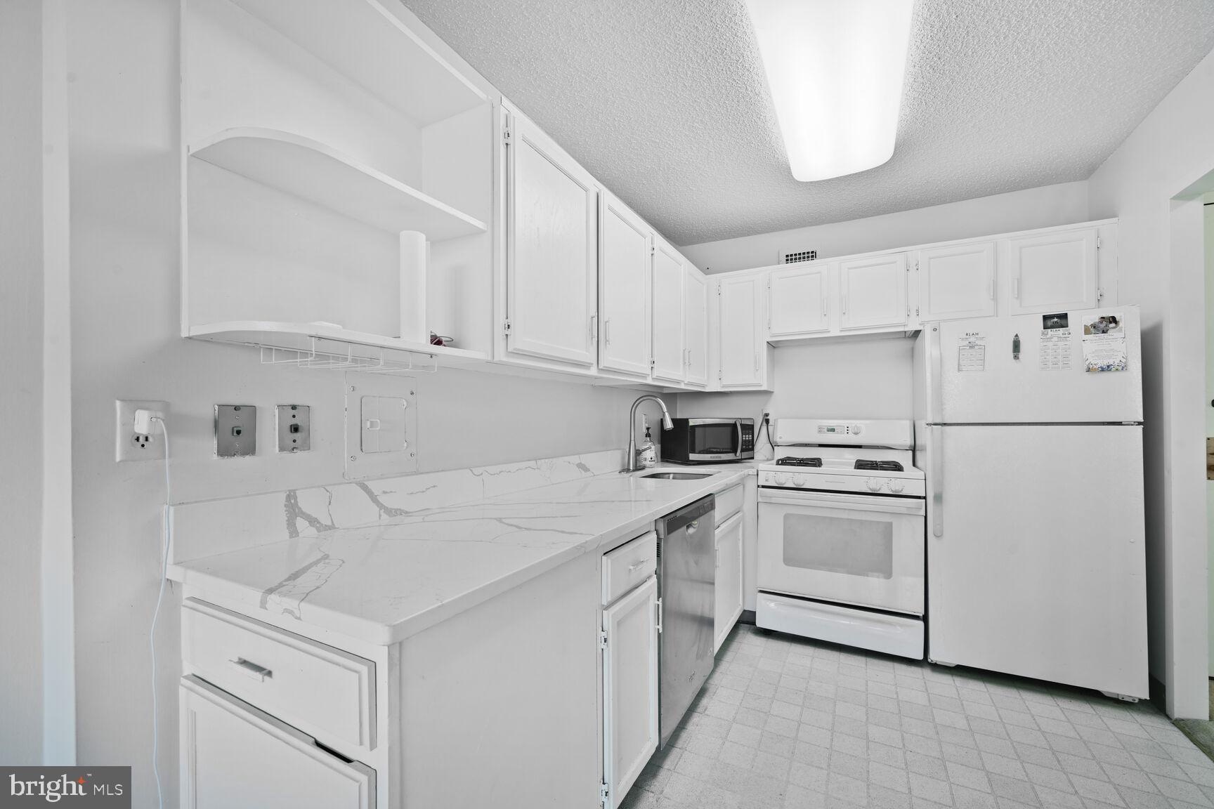 5225 Pooks Hill Road, Unit 1814N Bethesda, MD 20814 - Photo 4 of 31 a kitchen with white cabinets and white appliances