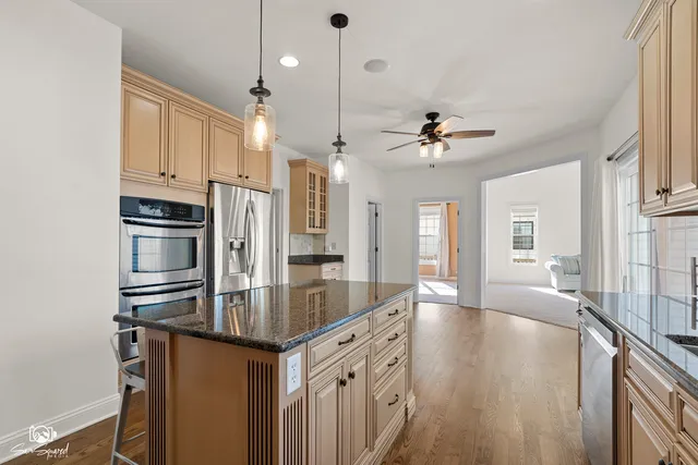 a kitchen with stainless steel appliances granite countertop a sink refrigerator and cabinets