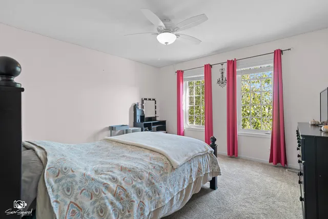 a spacious bedroom with a bed and a chandelier