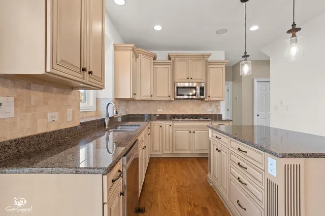 a kitchen with granite countertop a sink a counter top space appliances and cabinets