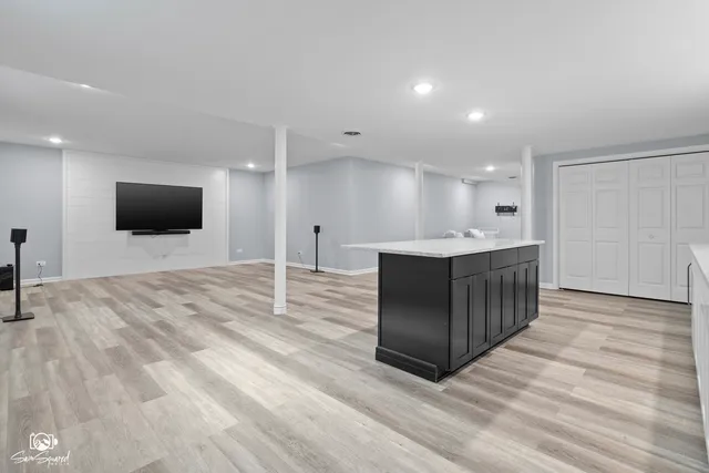 a spacious bathroom with a sink a mirror and a flat screen tv