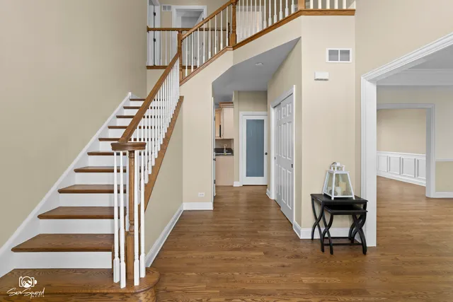 a view of a hallway with wooden floor and entryway