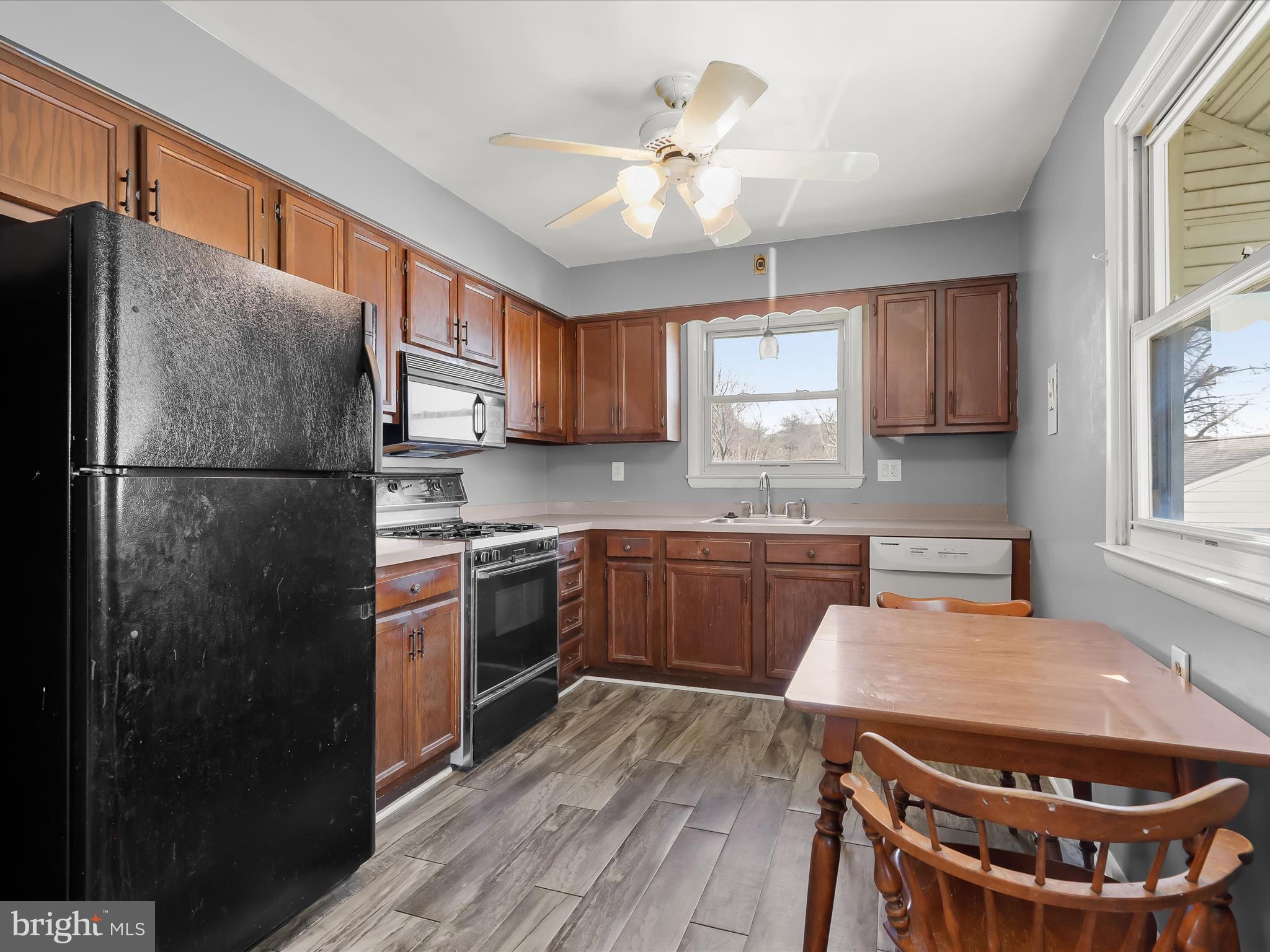 1543 South Rolling Road Halethorpe, MD 21227 - Photo 8 of 26 a kitchen with stainless steel appliances granite countertop a refrigerator a sink dishwasher a stove and white countertops with wooden floor