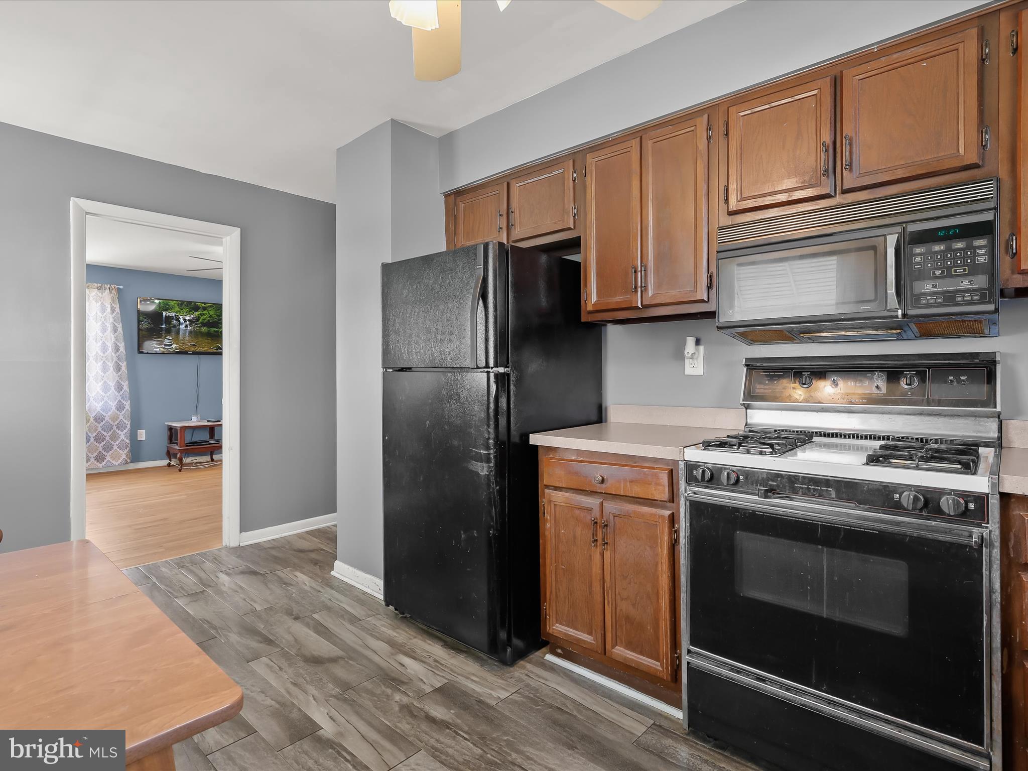 1543 South Rolling Road Halethorpe, MD 21227 - Photo 10 of 26 a kitchen with granite countertop wooden cabinets stainless steel appliances and wooden floor