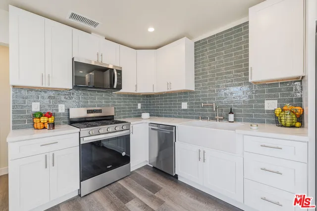 a kitchen with stainless steel appliances granite countertop a sink a stove and a granite counter tops