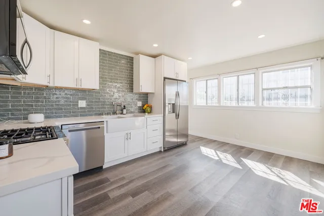a kitchen with granite countertop white cabinets and white appliances