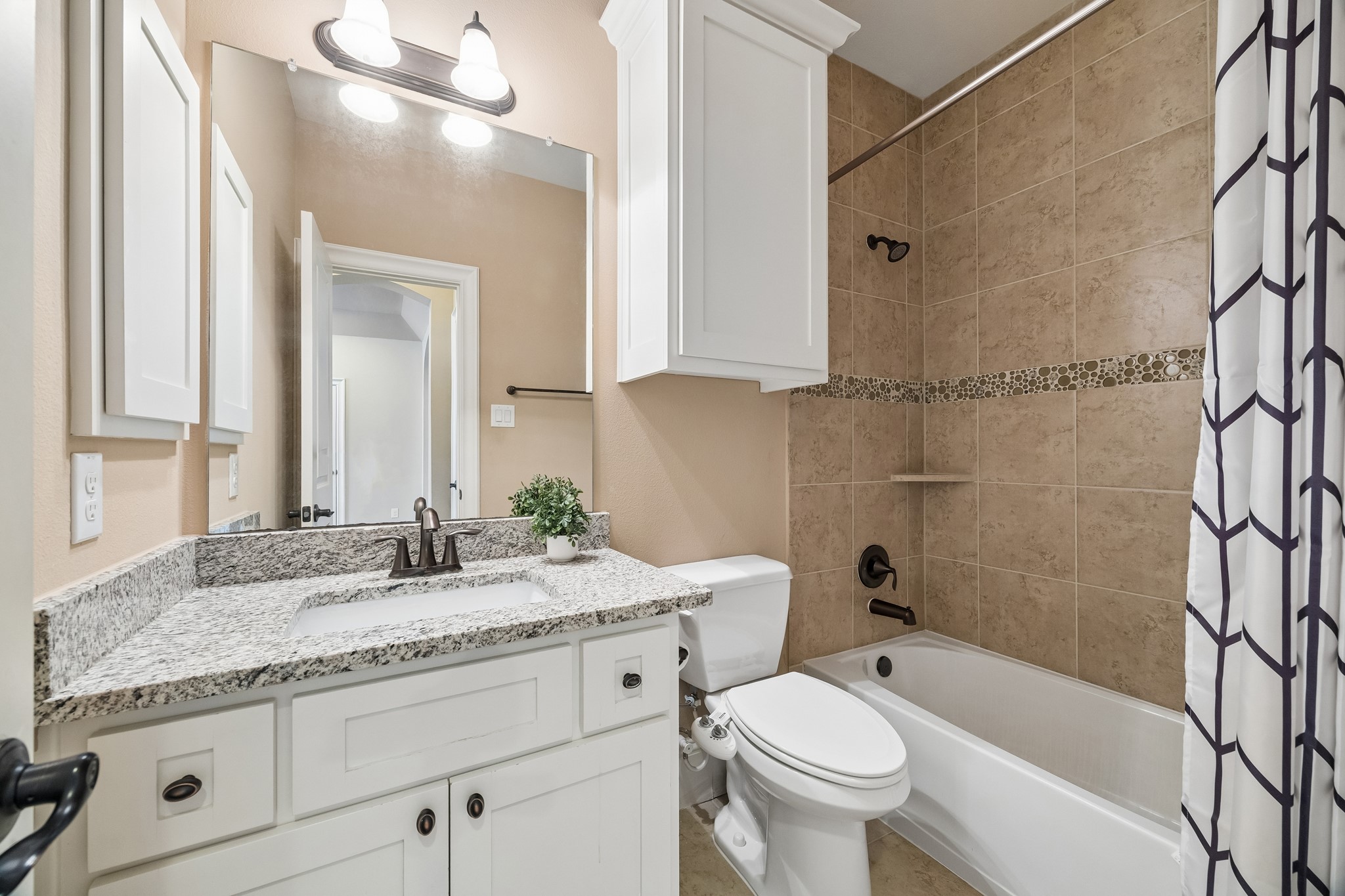 1360 Chippendale Road Houston, TX 77018 - Photo 22 of 34 Well-appointed secondary bath serving both the game room and adjacent secondary bedroom #1. Features granite countertops, vanity storage, tub/shower combination with tile surround, and a convenient linen closet located just outside in the hallway for additional storage.