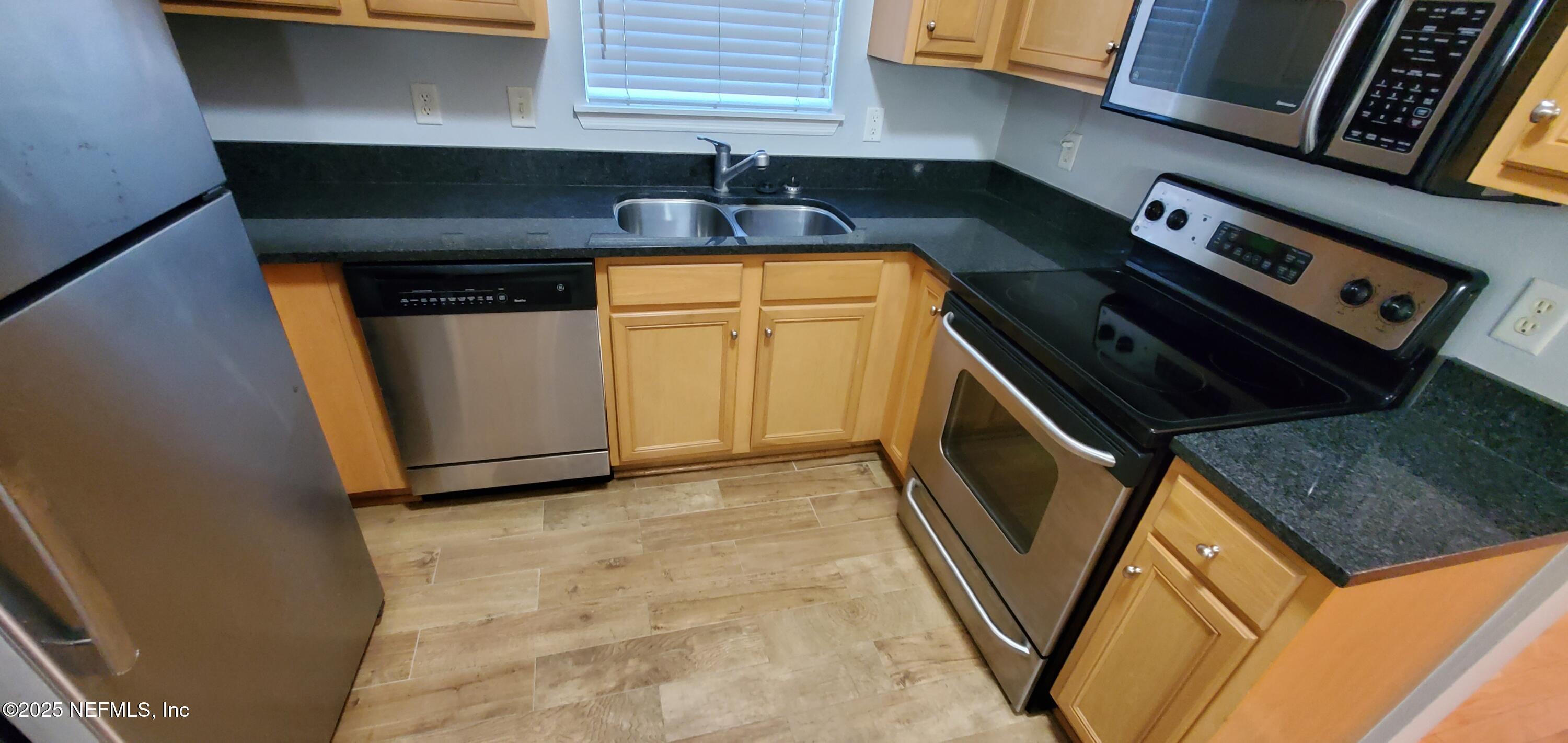 7800 Point Meadows Drive, Unit 1012 Jacksonville, FL 32256 - Photo 19 of 38 a kitchen with a stove and a microwave