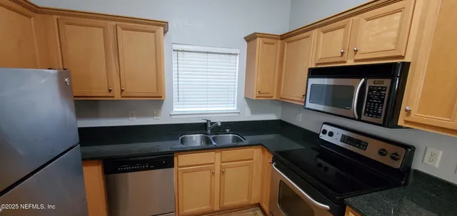 a kitchen with granite countertop cabinets and black appliances