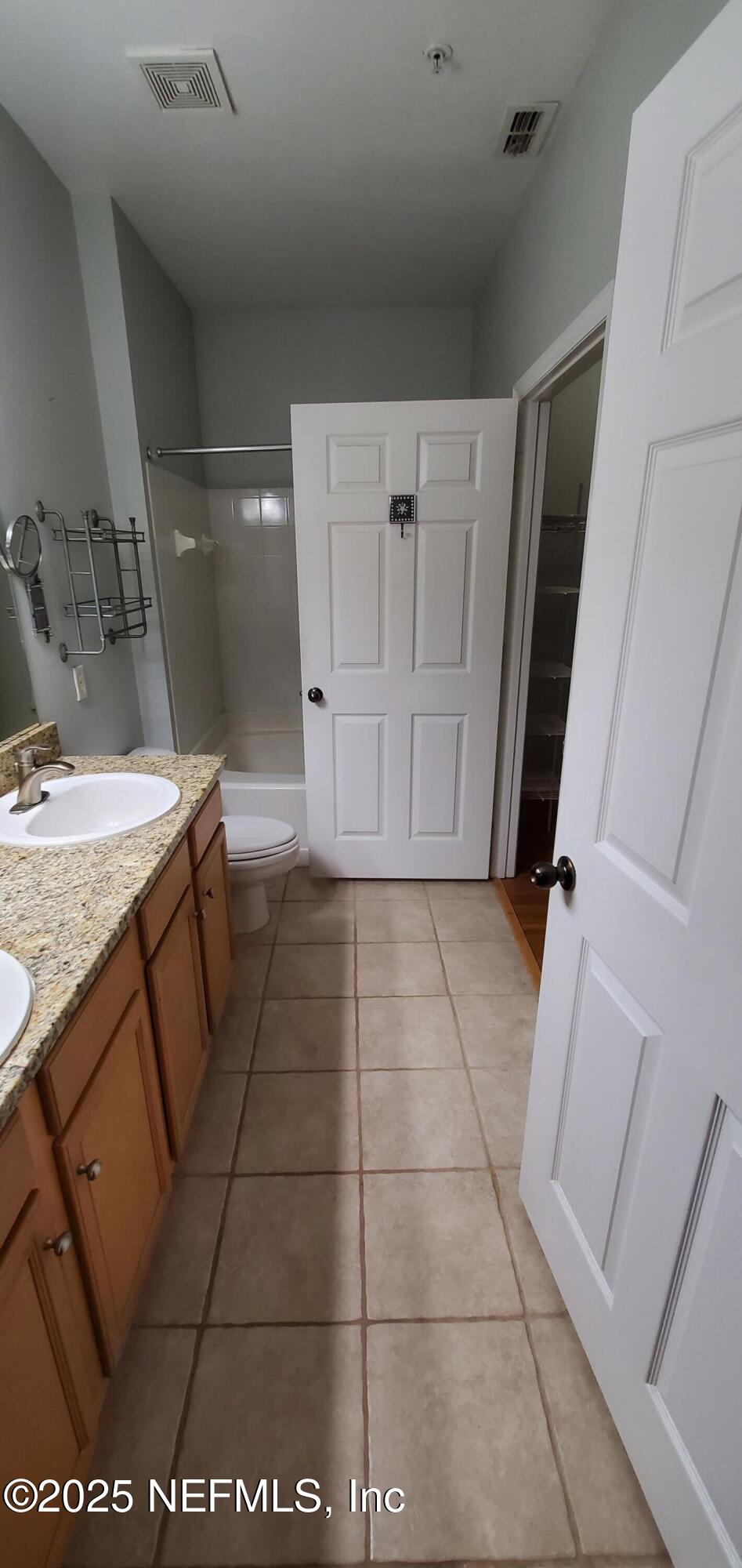 7800 Point Meadows Drive, Unit 1012 Jacksonville, FL 32256 - Photo 25 of 38 a bathroom with a granite countertop sink and a mirror
