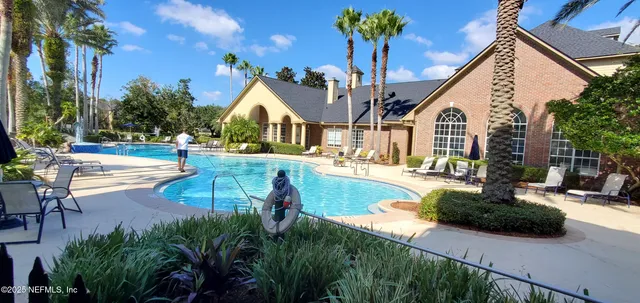 a view of a house with swimming pool and sitting area