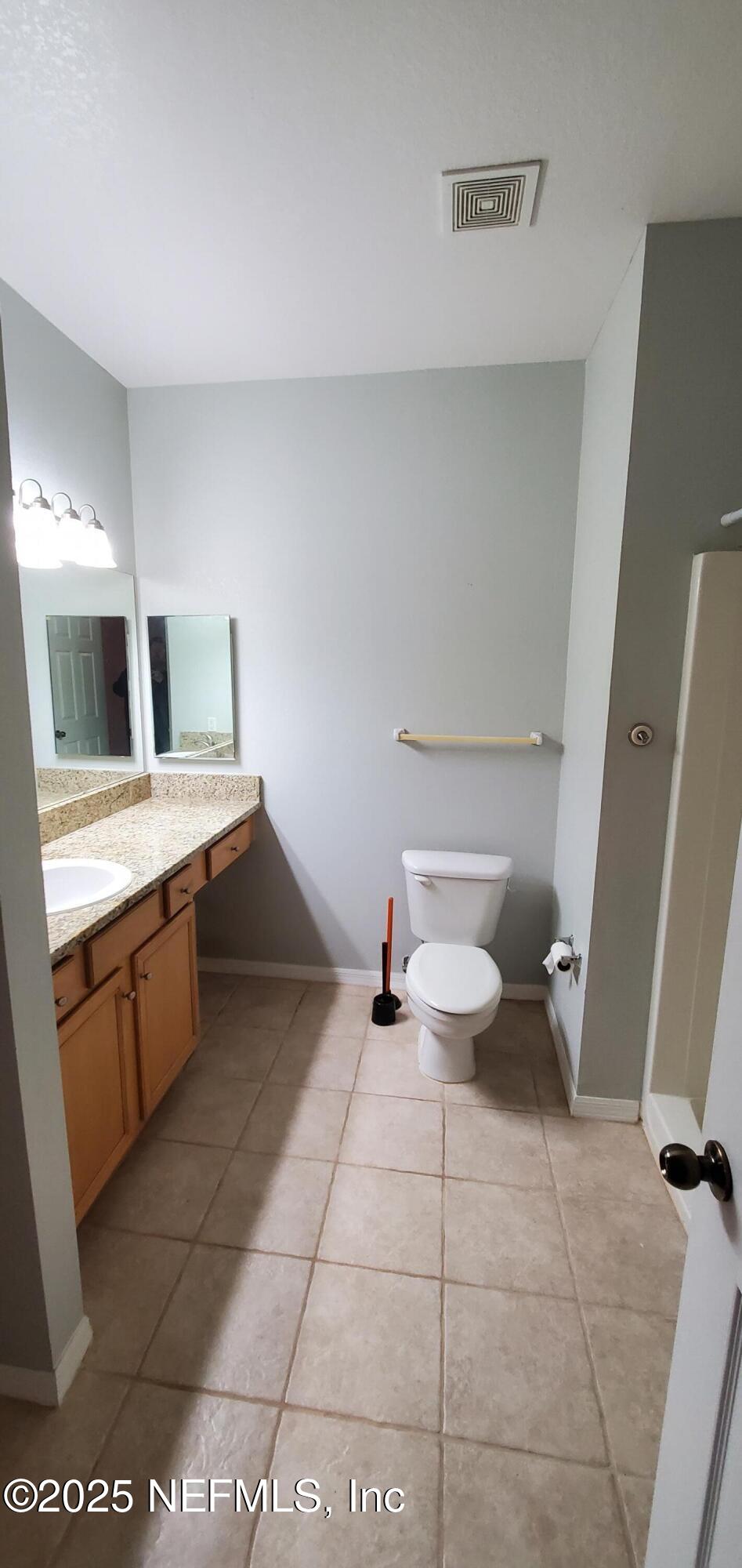 7800 Point Meadows Drive, Unit 1012 Jacksonville, FL 32256 - Photo 10 of 38 a bathroom with a sink a toilet and mirror