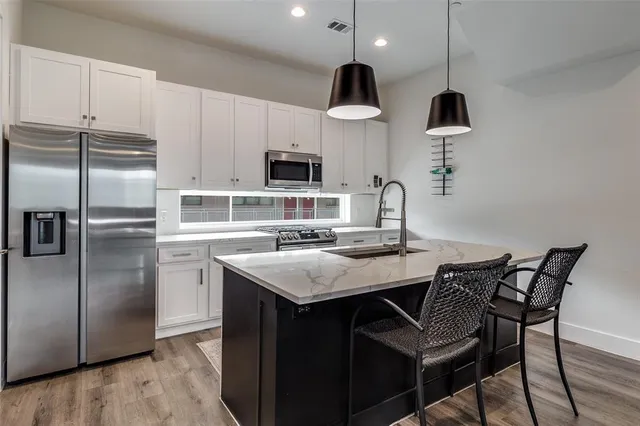 a kitchen with kitchen island a sink stove and refrigerator