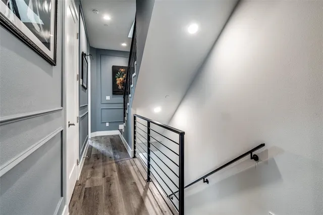 a view of a hallway with wooden floor and staircase