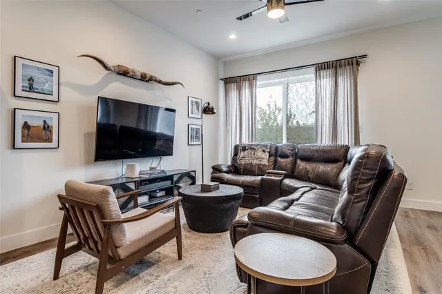 a living room with furniture a flat screen tv and a window