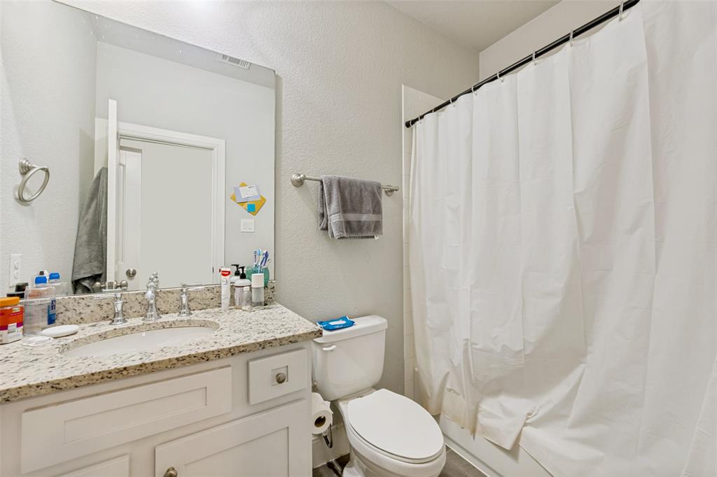 3545 Rashti Court Fort Worth, TX 76109 - Photo 21 of 36 a bathroom with a granite countertop sink toilet mirror and shower