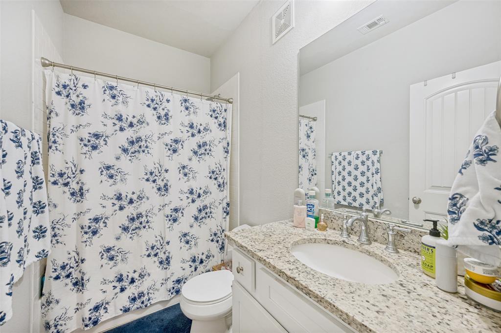 3545 Rashti Court Fort Worth, TX 76109 - Photo 33 of 36 a bathroom with a granite countertop sink a toilet and a mirror