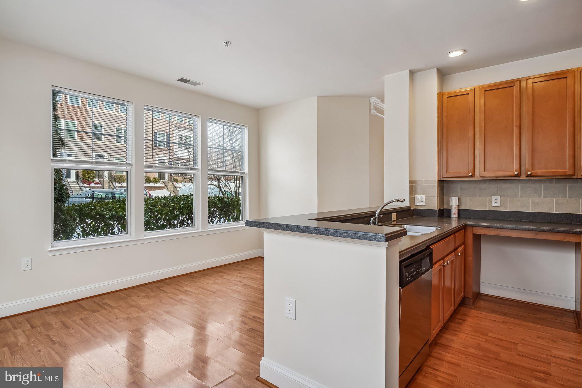 12824 Clarksburg Square Road, Unit 102 Clarksburg, MD 20871 - Photo 14 of 75 a kitchen with stainless steel appliances granite countertop a stove a sink and a microwave