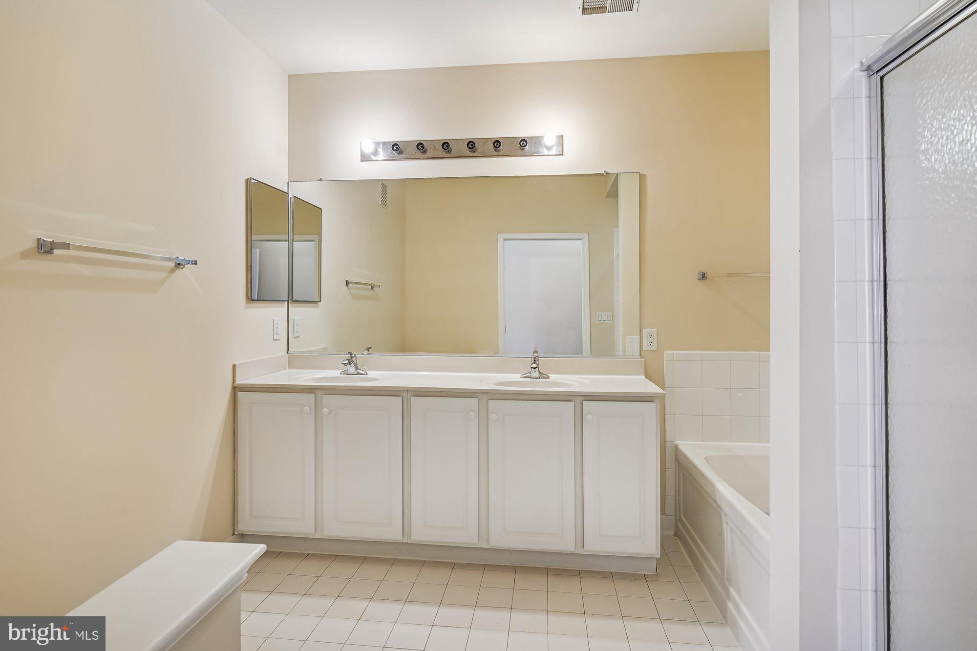 12824 Clarksburg Square Road, Unit 102 Clarksburg, MD 20871 - Photo 20 of 75 a bathroom with a sink a toilet and mirror