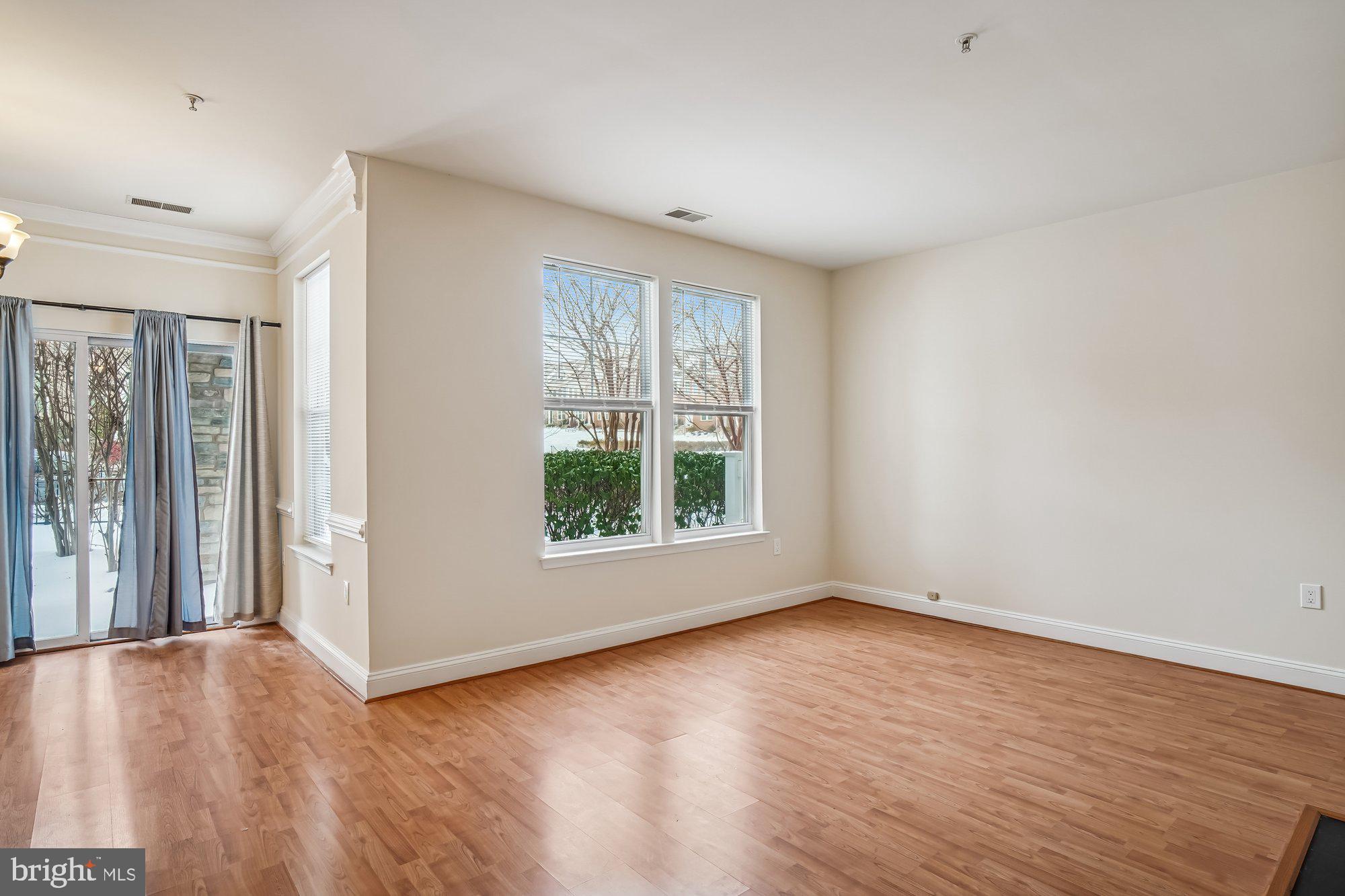 12824 Clarksburg Square Road, Unit 102 Clarksburg, MD 20871 - Photo 9 of 75 an empty room with wooden floor and windows