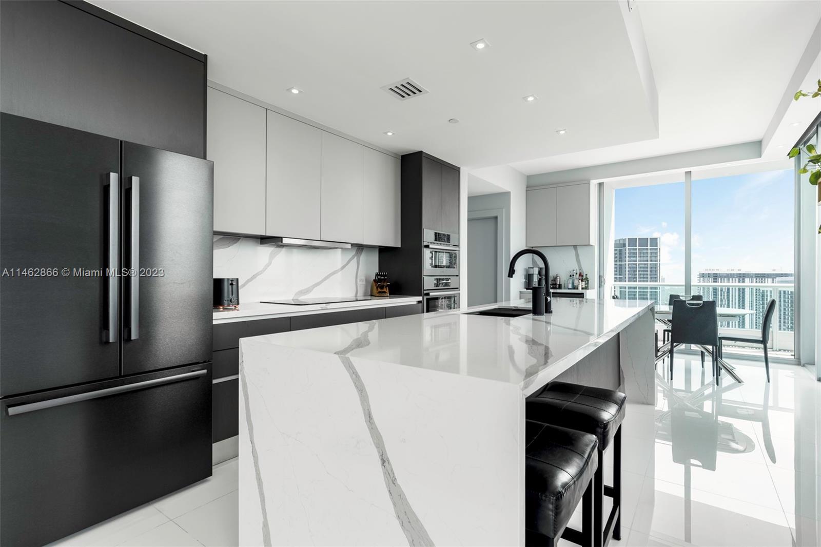 900 Biscayne Boulevard, Unit 5012 Miami, FL 33132 - Photo 6 of 27 a kitchen with kitchen island a counter top space a sink appliances and cabinets