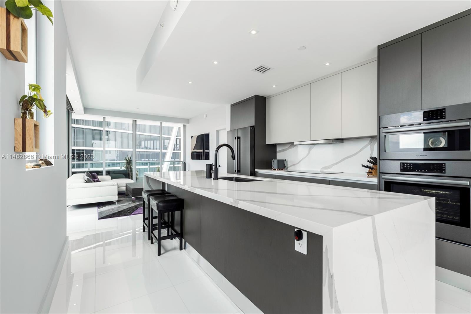 900 Biscayne Boulevard, Unit 5012 Miami, FL 33132 - Photo 7 of 27 a kitchen with a sink a stove and chairs with wooden floor