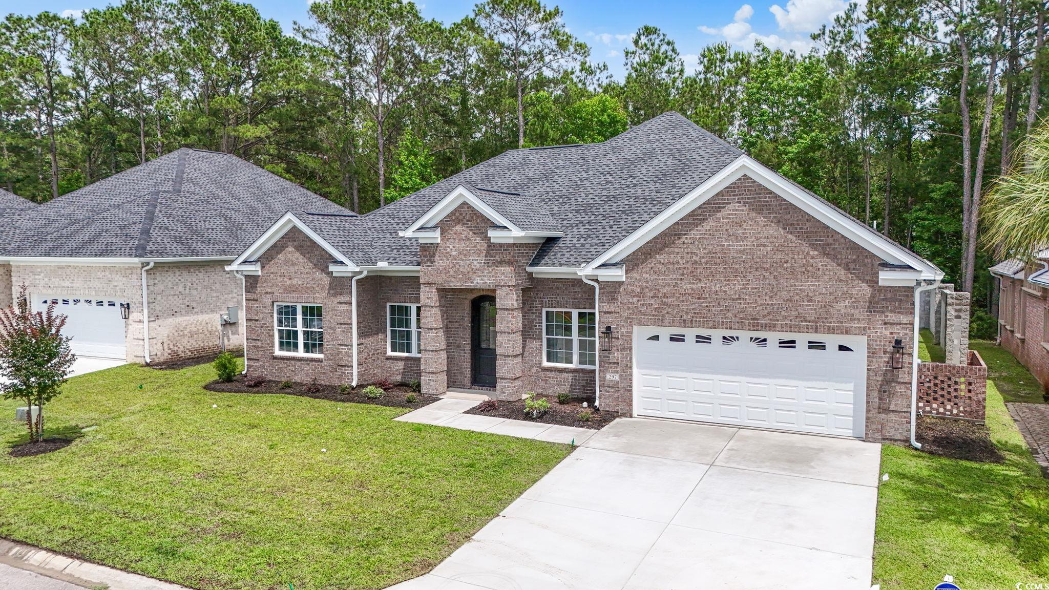 297 Waterfall Circle Little River, SC 29566 - Photo 2 of 40 View of front of house featuring an attached garage, driveway, brick siding, a front lawn, and roof with shingles