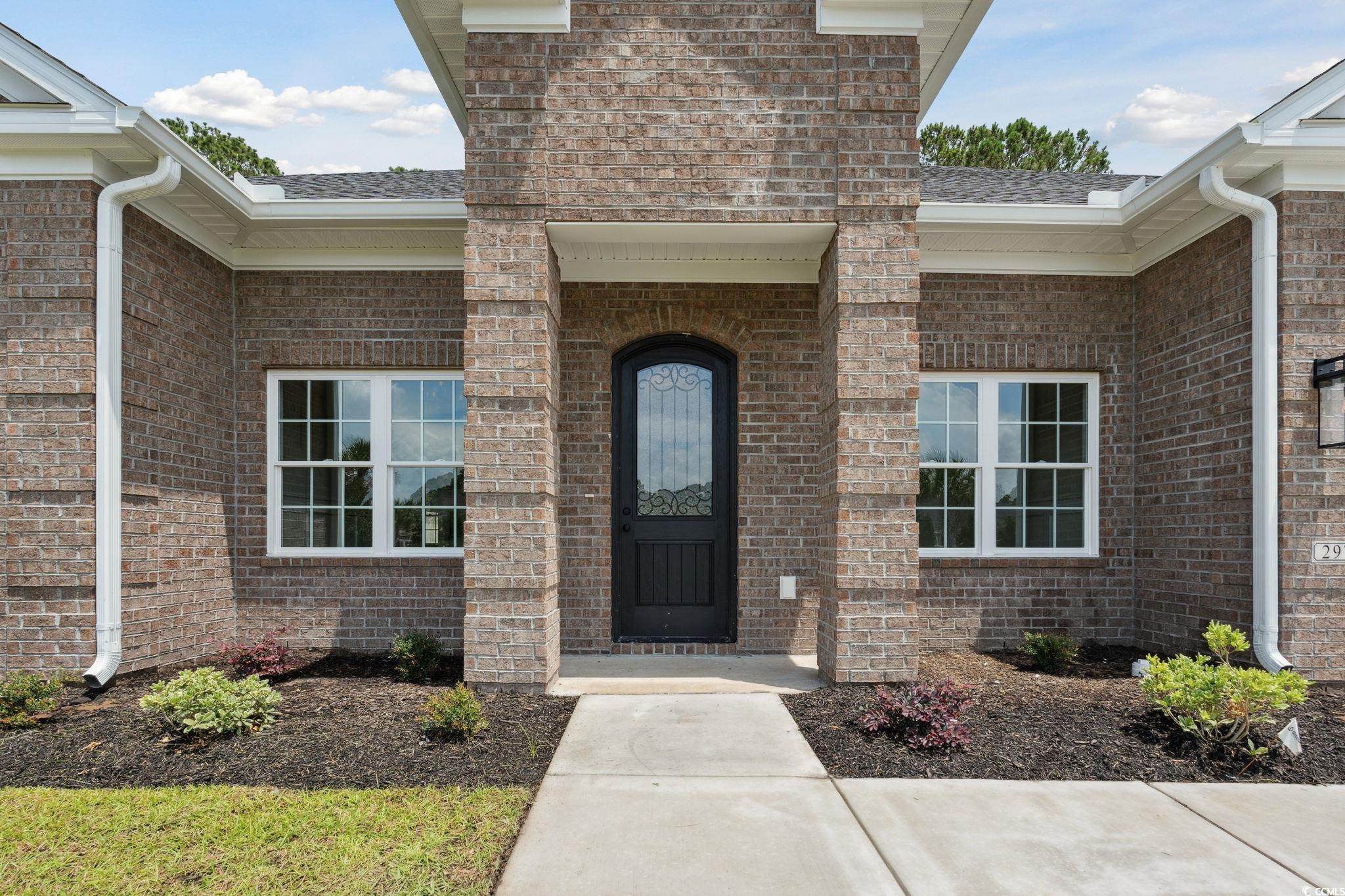 297 Waterfall Circle Little River, SC 29566 - Photo 4 of 40 Doorway to property featuring brick siding and a shingled roof