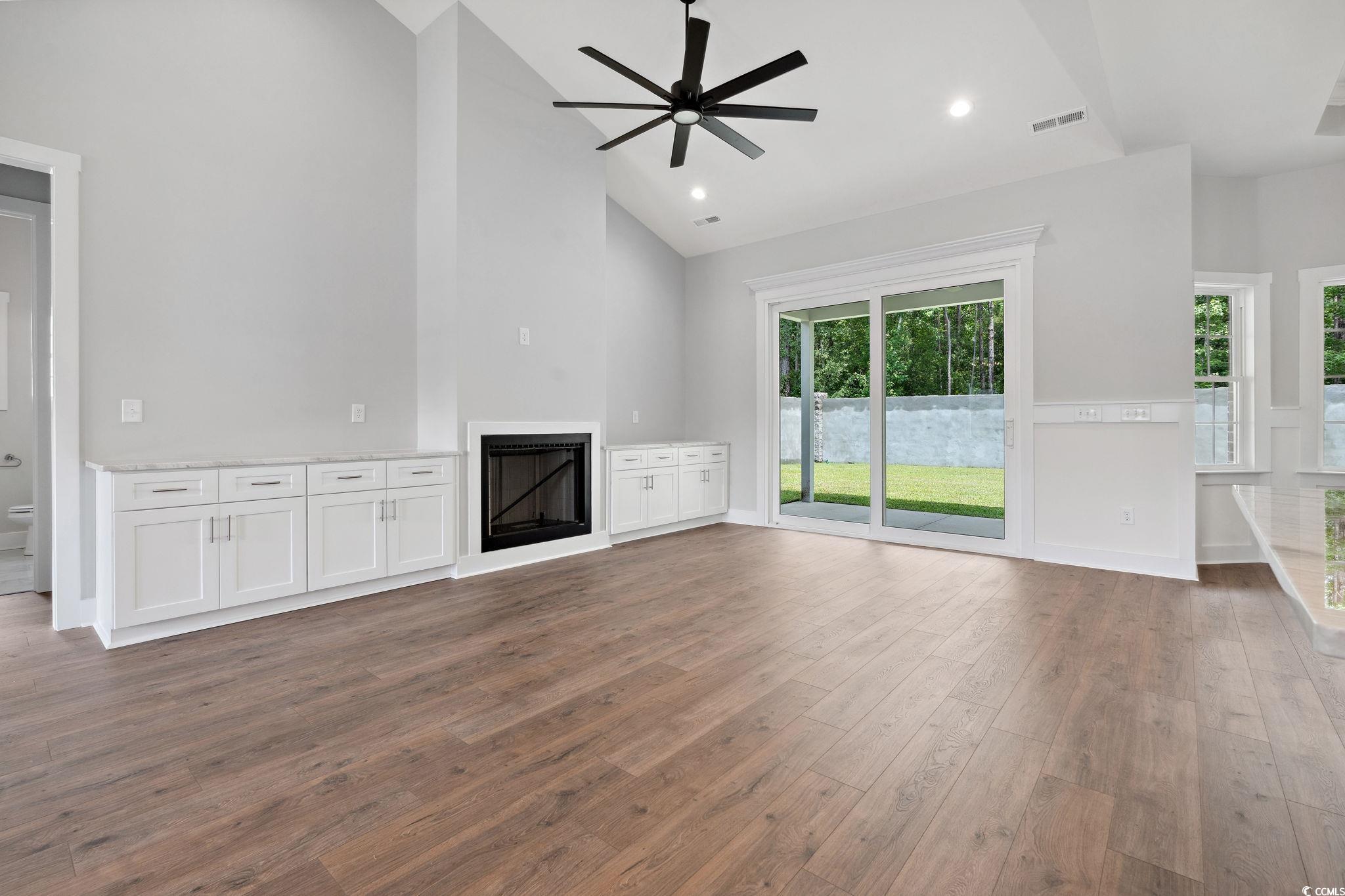 297 Waterfall Circle Little River, SC 29566 - Photo 7 of 40 Unfurnished living room with a fireplace, ceiling fan, hardwood / wood-style floors, high vaulted ceiling, and recessed lighting