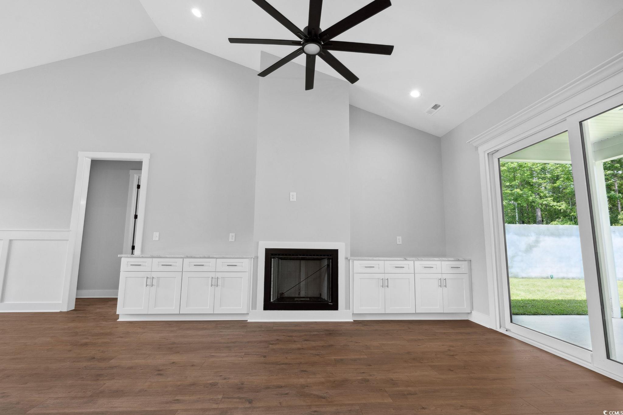 297 Waterfall Circle Little River, SC 29566 - Photo 8 of 40 Unfurnished living room with a glass covered fireplace, high vaulted ceiling, a ceiling fan, dark wood-type flooring, and recessed lighting