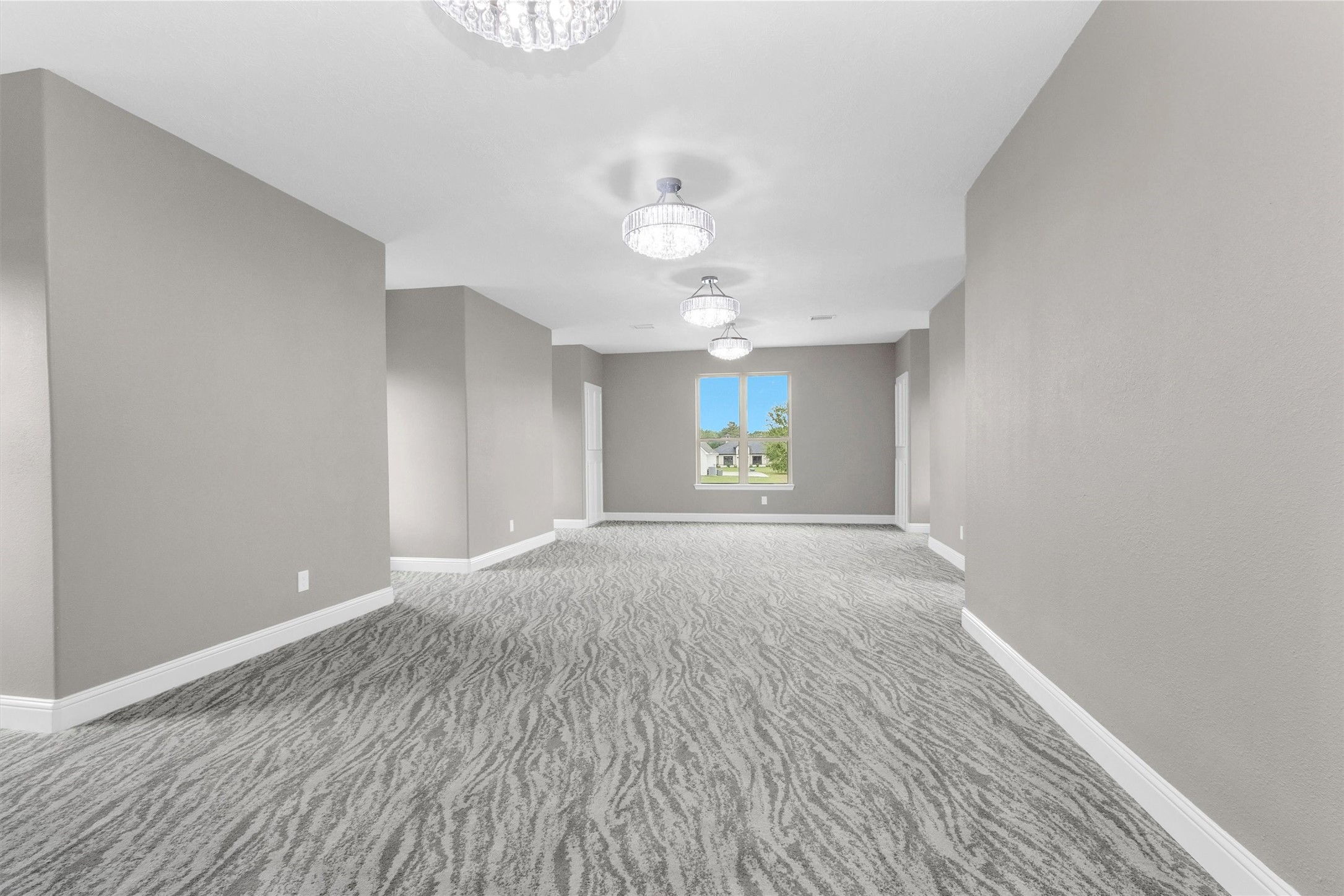 10887 Decatur Street Willis, TX 77318 - Photo 42 of 50 Massive upstairs gameroom with an extended layout, multiple chandelier fixtures, and plenty of wall space for media, gaming, or a full lounge setup—perfect for entertaining on a larger scale or creating a dedicated second living area.
