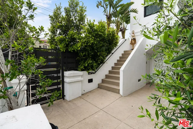 a view of a porch with potted plants and couches