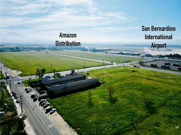 a view of a swimming pool with lawn chairs and large trees