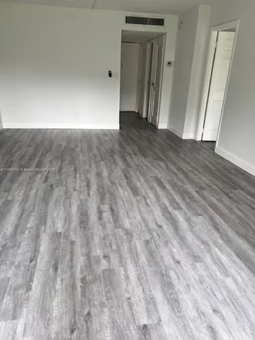 a view of an empty room and wooden floor