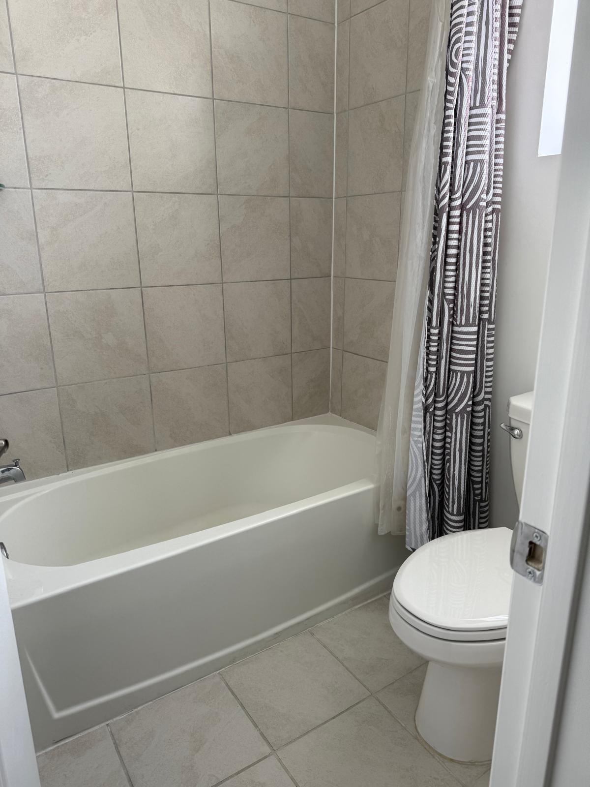 12736 Southwest 211th Street Miami, FL 33177 - Photo 13 of 18 a white toilet and tub sitting next to a bathroom sink