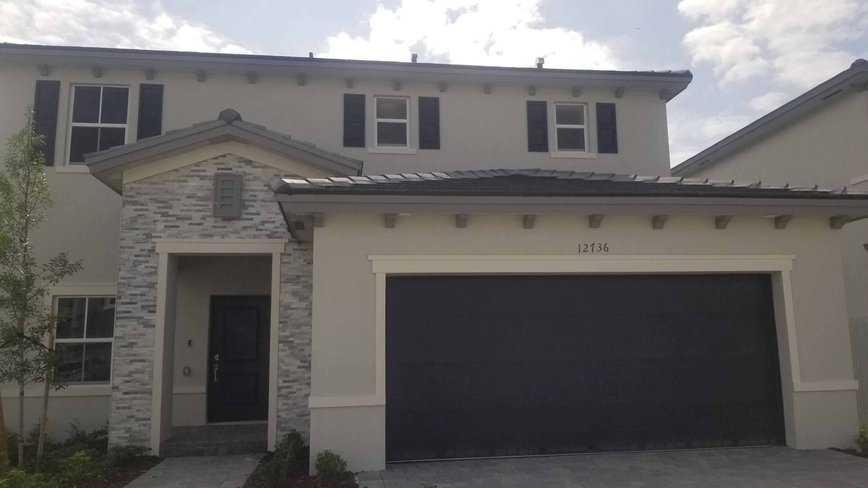 12736 Southwest 211th Street Miami, FL 33177 - Photo 2 of 18 a front view of a house with a garage