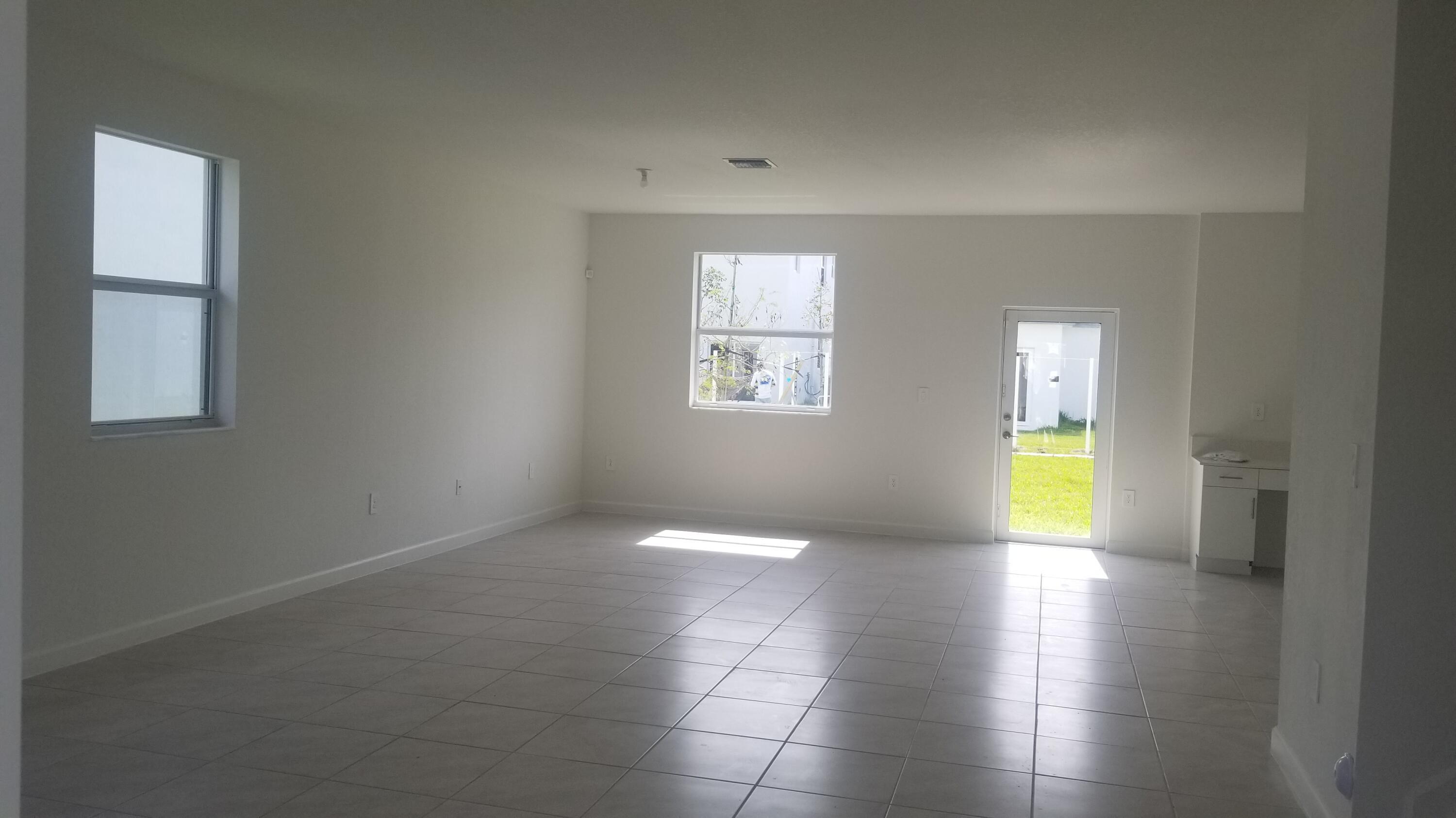 12736 Southwest 211th Street Miami, FL 33177 - Photo 3 of 18 wooden floor in an empty room with a window